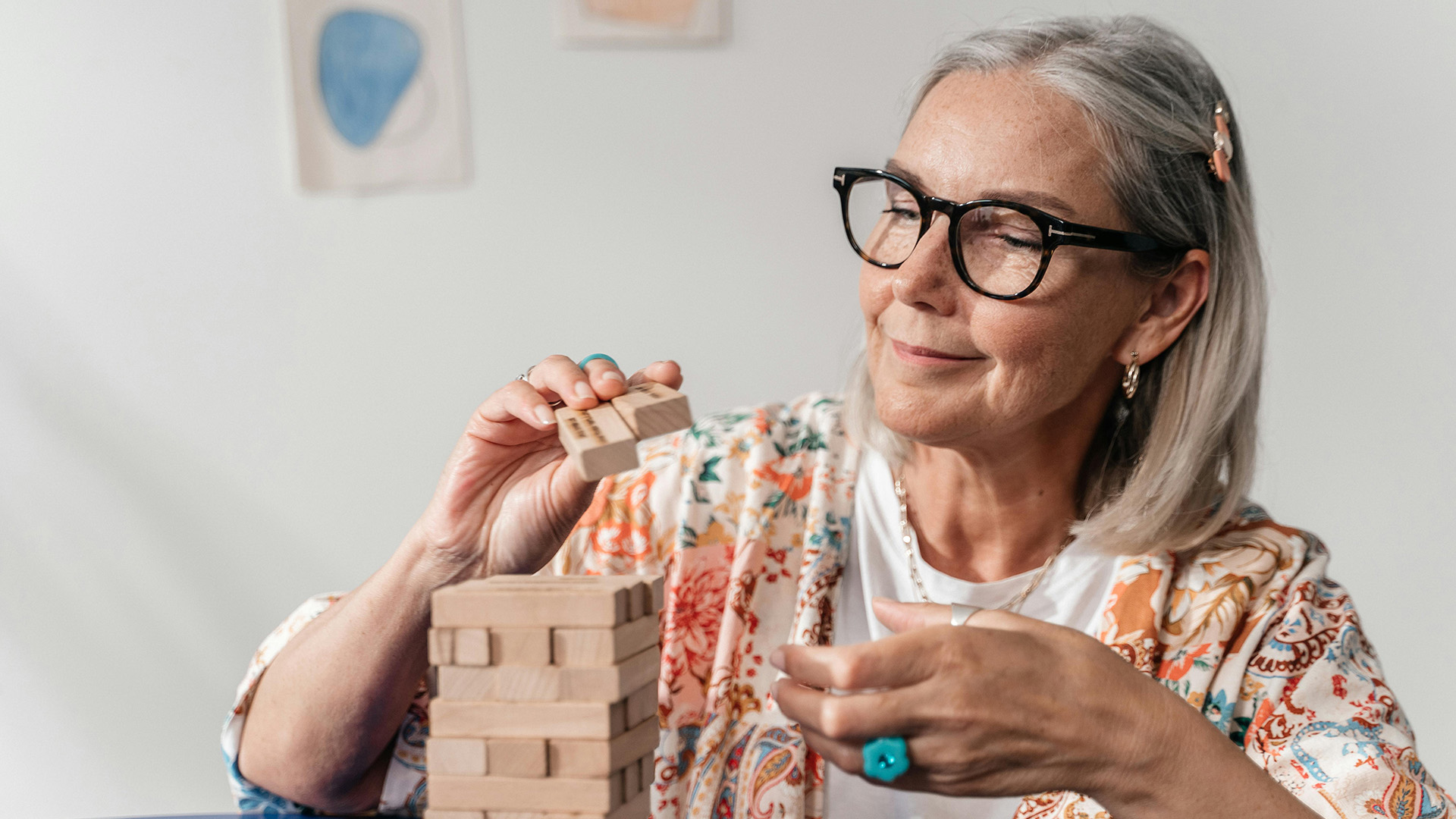 Older woman setting up a wooden block game