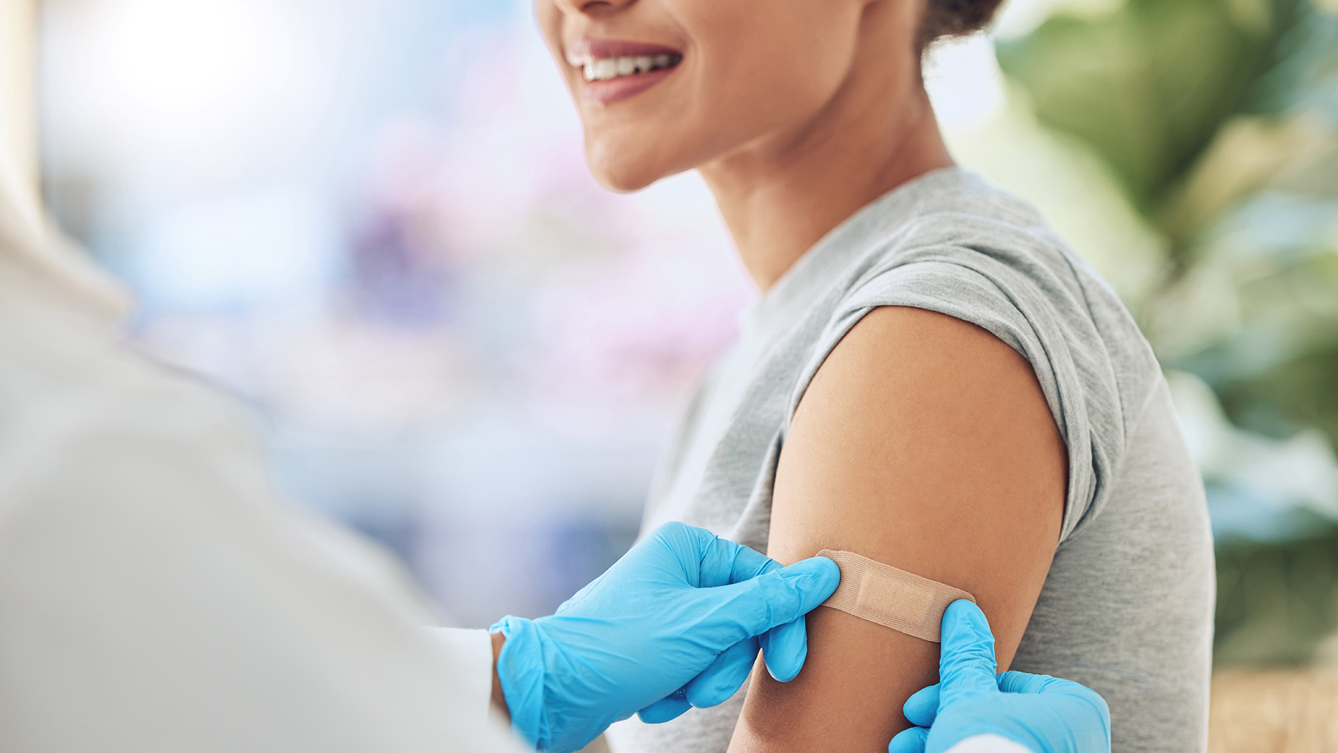 provider putting a bandaid on a patient's arm after a vaccine